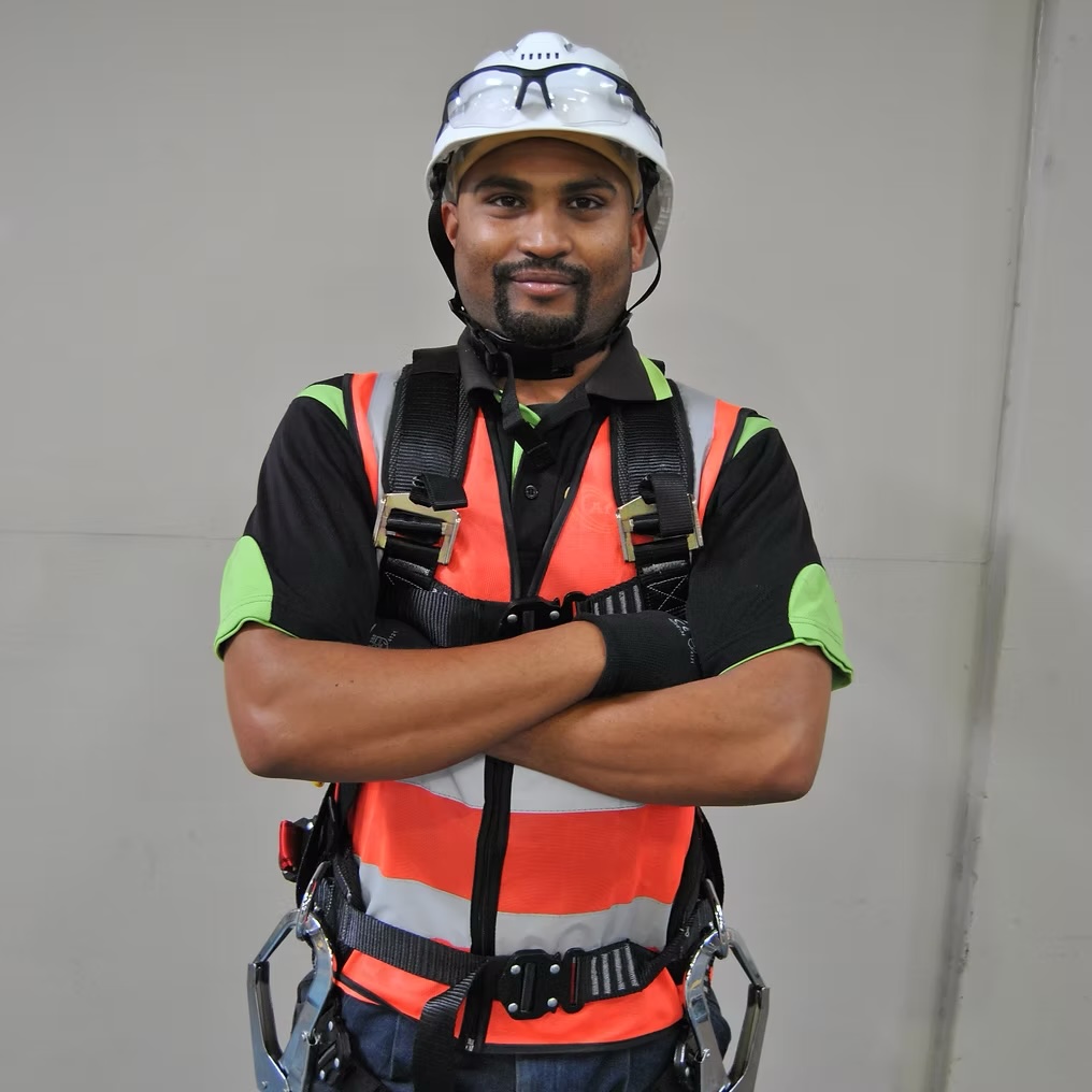Worker in full PPE – hard hat, safety glasses, hi-vis vest and fall-arrest harness – supplied by Afrishore PPE supplier in Mossel Bay.